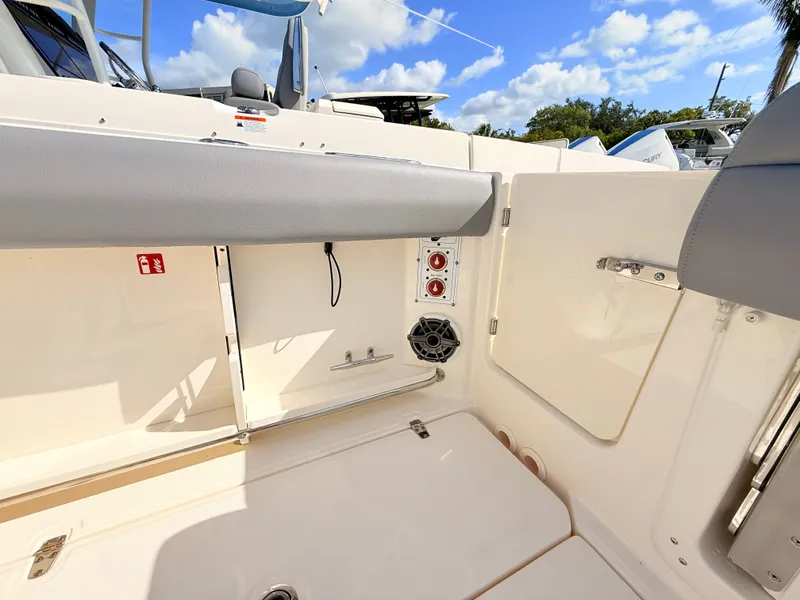 Slide: The Image of The image shows the interior of a 2026 Boston Whaler 280 Outrage with gray upholstery and speakers. - 20