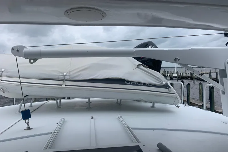 Slide: The Image of 1999 Hatteras 52 Cockpit Motor Yacht with covered dinghy on deck, docked at marina. - 15