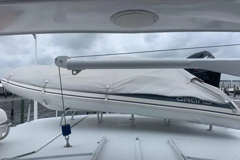 Slide: The Image of 1999 Hatteras 52 Cockpit Motor Yacht with covered dinghy on deck, cloudy sky background. - 16