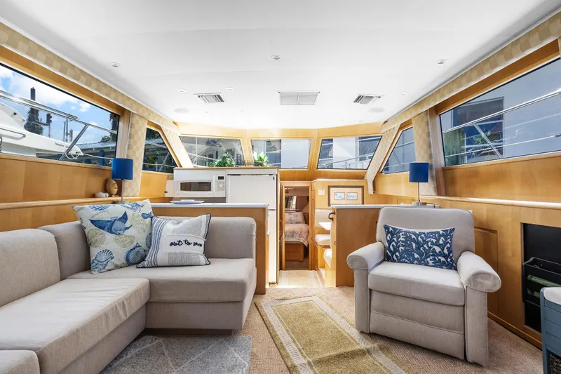 Slide: The Image of Interior of 1999 Hatteras 52 Cockpit Motor Yacht with cozy seating and modern decor. - 23