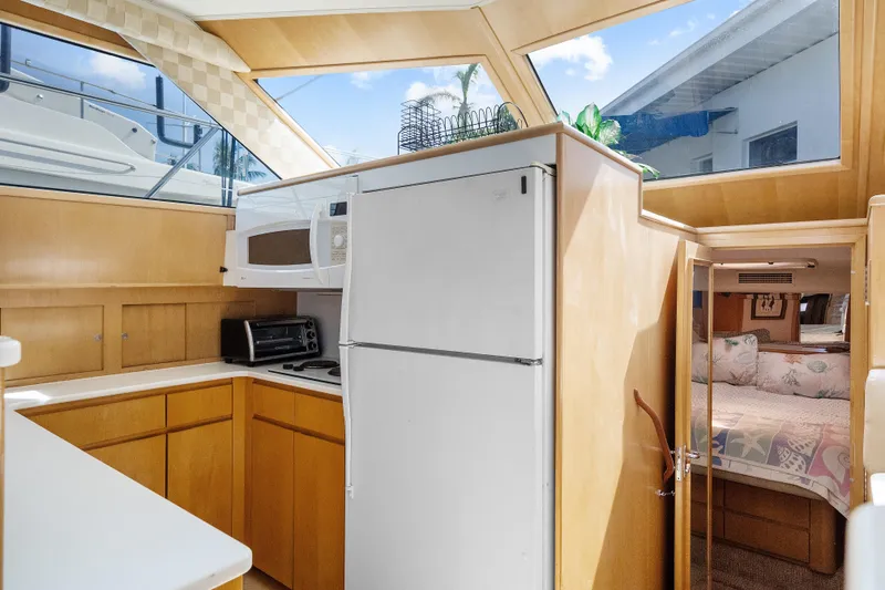 Slide: The Image of Interior of 1999 Hatteras 52 Cockpit Motor Yacht with kitchen and cozy bedroom. - 25