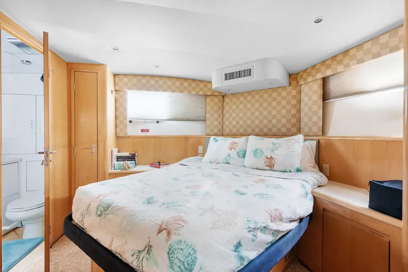 Slide: The Image of Cozy bedroom in 1999 Hatteras 52 Cockpit Motor Yacht with nautical-themed bedding. - 28