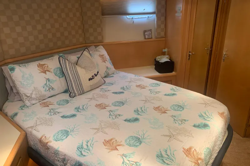 Slide: The Image of Cozy bedroom in 1999 Hatteras 52 Cockpit Motor Yacht with nautical-themed bedding. - 29