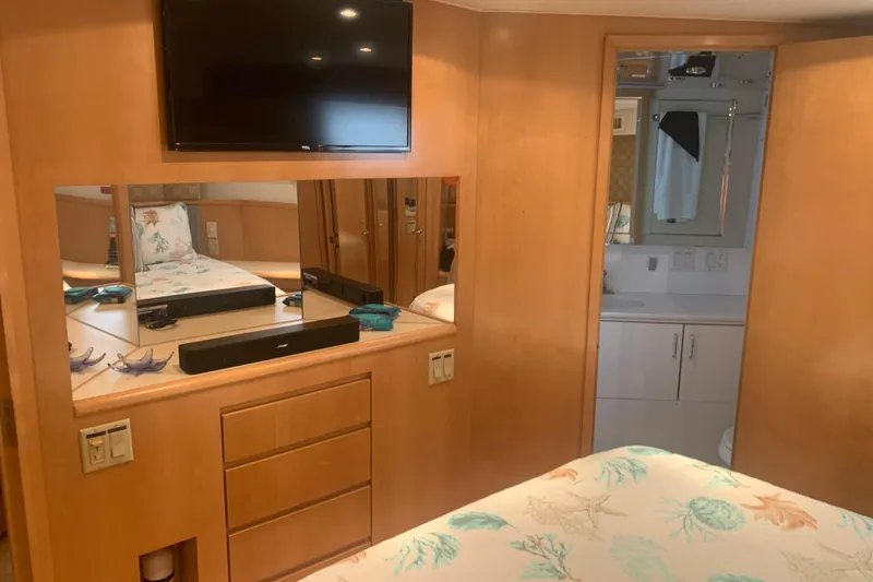 Slide: The Image of Interior of 1999 Hatteras 52 Cockpit Motor Yacht with TV, mirror, and bathroom. - 30