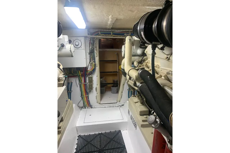 Slide: The Image of Engine room of 1999 Hatteras 52 Cockpit Motor Yacht with visible wiring and equipment. - 34