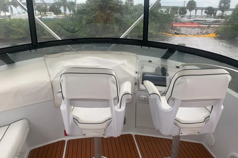 Slide: The Image of Cockpit view of 1999 Hatteras 52 Cockpit Motor Yacht with white seating and wood flooring. - 5