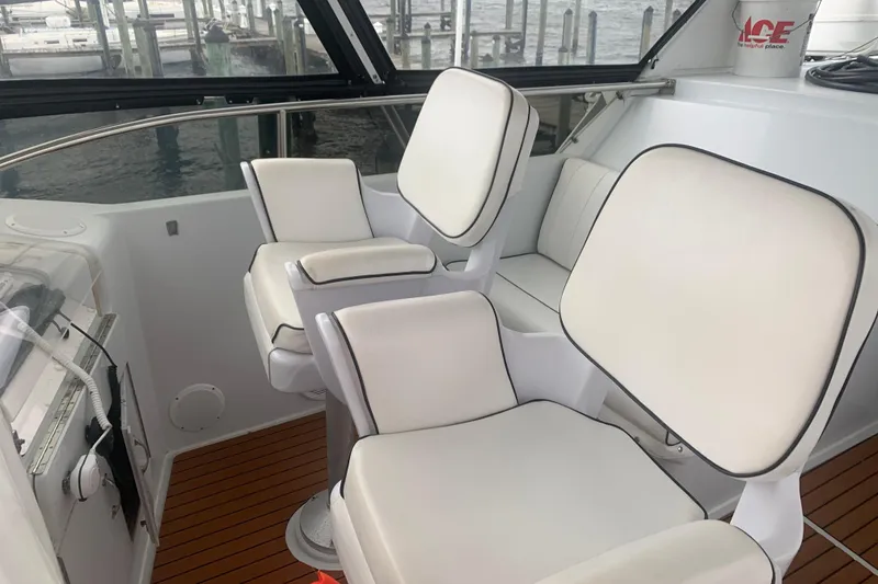 Slide: The Image of Interior of 1999 Hatteras 52 Cockpit Motor Yacht with white cushioned seating. - 6