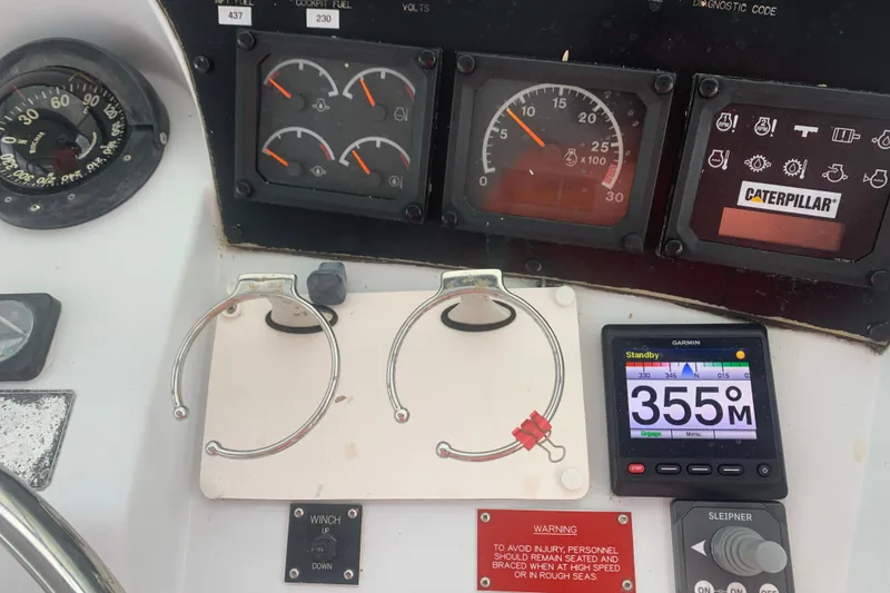 Slide: The Image of Control panel of a 1999 Hatteras 52 Cockpit Motor Yacht with gauges and navigation display. - 9
