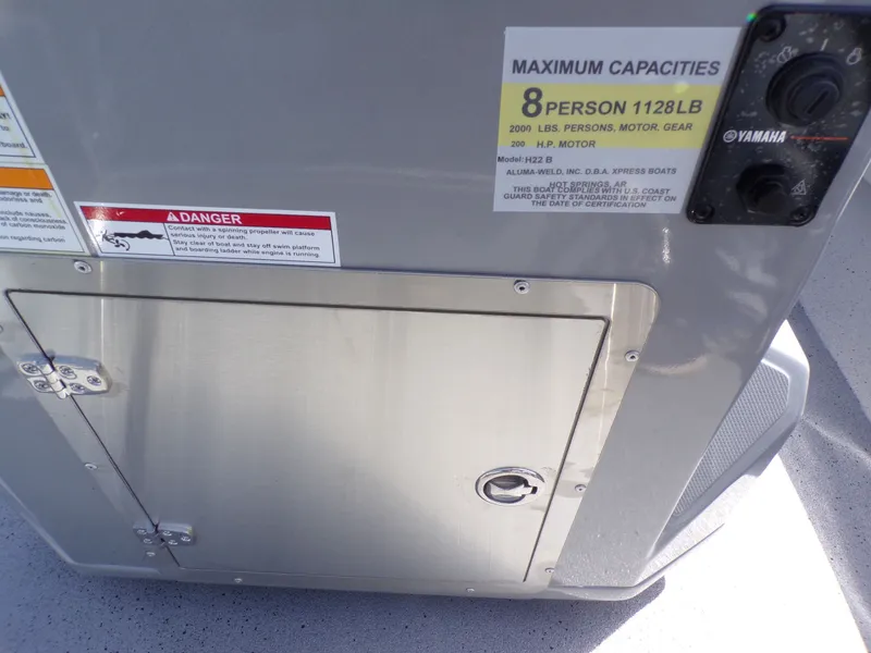 Slide: The Image of Xpress H22B Bay 2026 boat capacity label and warning signs. - 14