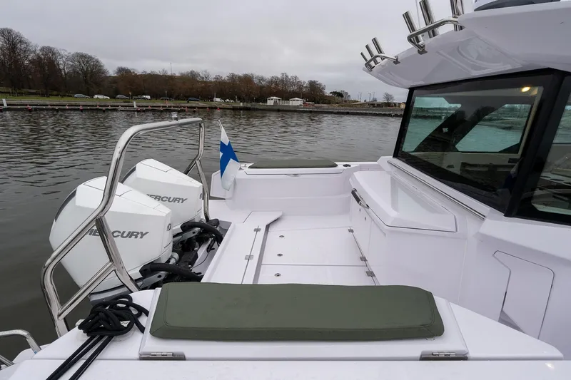 Slide: The Image of 2027 Axopar 38 Cross Cabin boat with Mercury engines on a calm lake. - 10