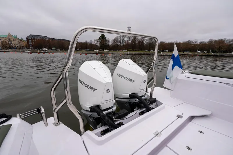 Slide: The Image of 2027 Axopar 38 Cross Cabin with dual Mercury outboard engines on a calm lake. - 16