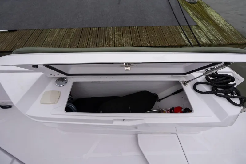 Slide: The Image of Open storage compartment on 2027 Axopar 38 Cross Cabin boat, showing ropes and equipment. - 21