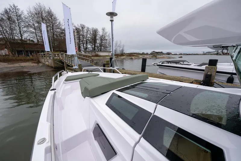 Slide: The Image of 2027 Axopar 38 Cross Cabin docked by a wooden pier on a cloudy day. - 24