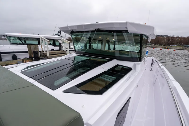 Slide: The Image of 2027 Axopar 38 Cross Cabin boat docked, featuring sleek design and modern windows. - 35