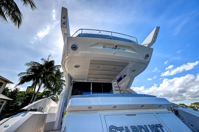 Slide: The Image of 2020 Sunseeker Manhattan 52 yacht under blue sky with palm trees. - 13