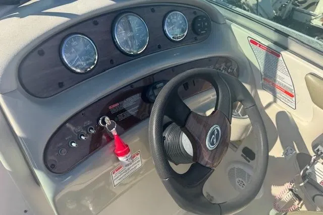 Slide: The Image of 2005 Sea Ray 240 Sundeck dashboard with steering wheel and instrument panel. - 8