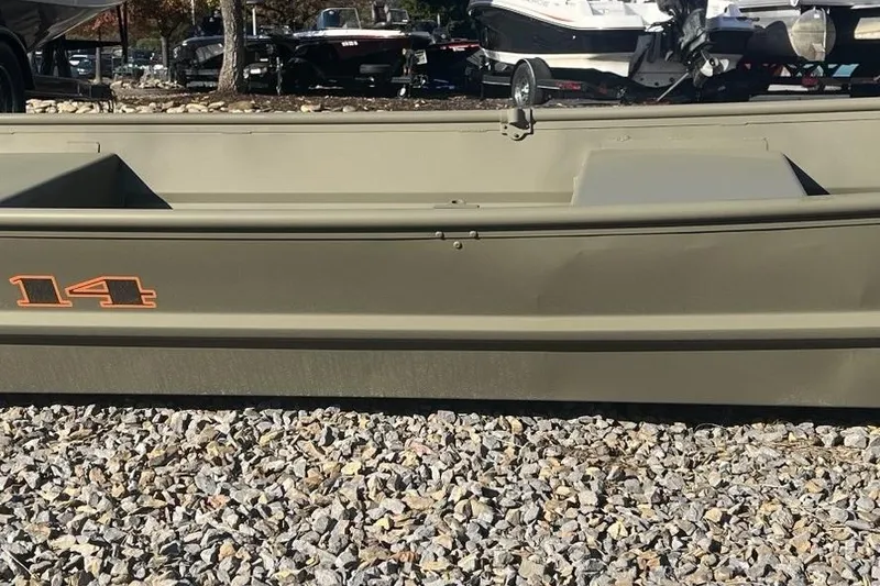 Slide: The Image of 2026 Tracker Grizzly 14 Jon boat on gravel, showcasing side view and model number. - 2