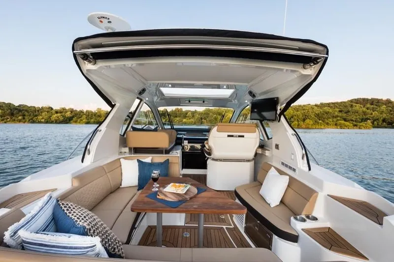 Slide: The Image of Manufacturer Provided Image: 2021 Sea Ray Sundancer 350 Coupe luxury yacht interior with seating and table on a serene lake. - 17