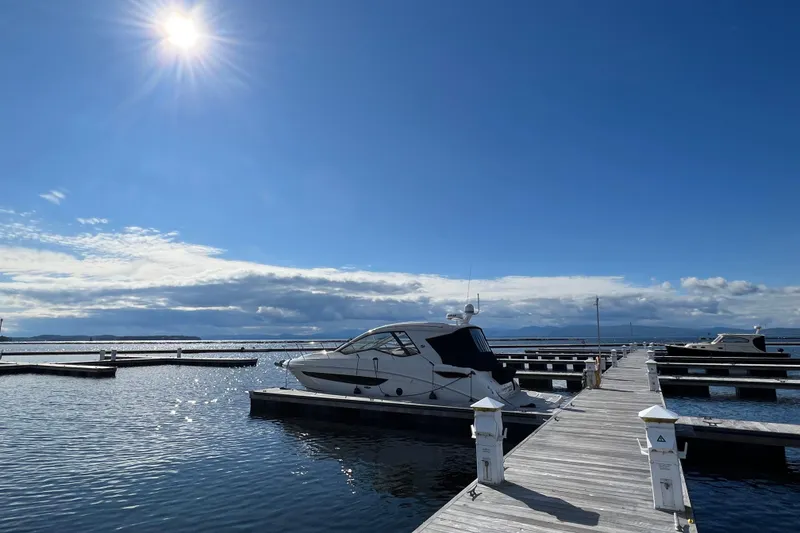 Slide: The Image of 2021 Sea Ray Sundancer 350 Coupe docked under a bright sunlit sky. - 2