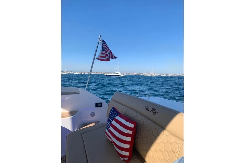 Slide: The Image of 2021 Sea Ray Sundancer 350 Coupe with American flag on open water. - 7