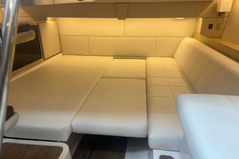 Slide: The Image of 2024 Regal 36 XO yacht interior with luxurious white seating and ambient lighting. - 28