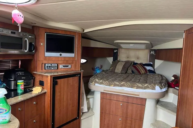 Slide: The Image of 2008 Cruisers Yachts 360 Express interior with bed, kitchenette, and entertainment system. - 5