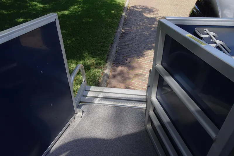 Slide: The Image of 2018 Veranda VF22TT boat deck with railing, near grassy area and cobblestone path. - 20