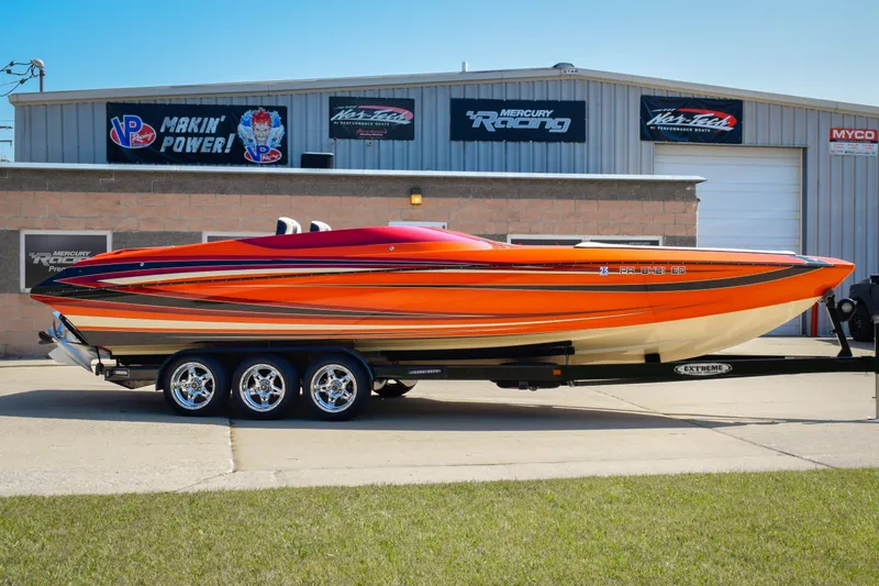 The Image of 2012 DCB 28 Extreme speedboat with vibrant orange and red design on a trailer. - 0