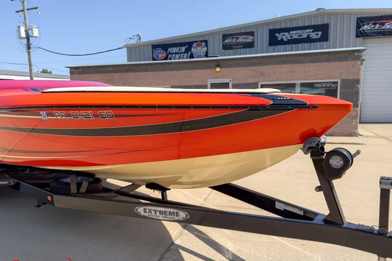 Slide: The Image of 2012 DCB 28 Extreme boat with vibrant orange and black design on trailer. - 10