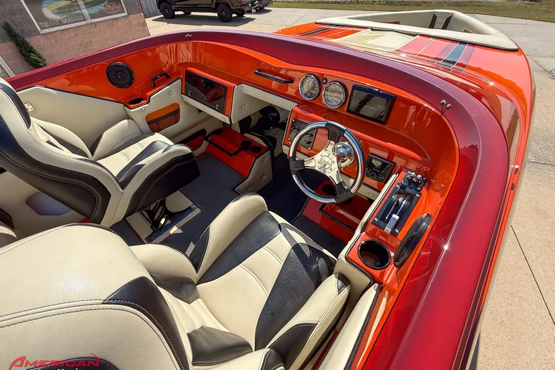 Slide: The Image of Interior of a 2012 DCB 28 Extreme boat with red accents and modern controls. - 11
