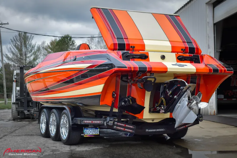 Slide: The Image of 2012 DCB 28 Extreme powerboat with vibrant orange and black stripes on a trailer. - 4