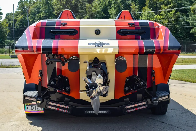 Slide: The Image of 2012 DCB 28 Extreme boat, vibrant red and black design, rear view with dual propellers. - 5