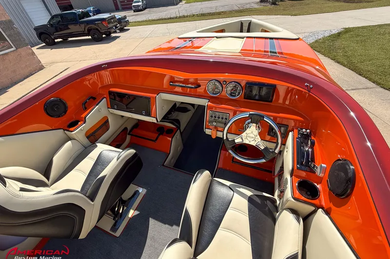 Slide: The Image of Interior of a 2012 DCB 28 Extreme boat with vibrant orange dashboard and modern controls. - 9