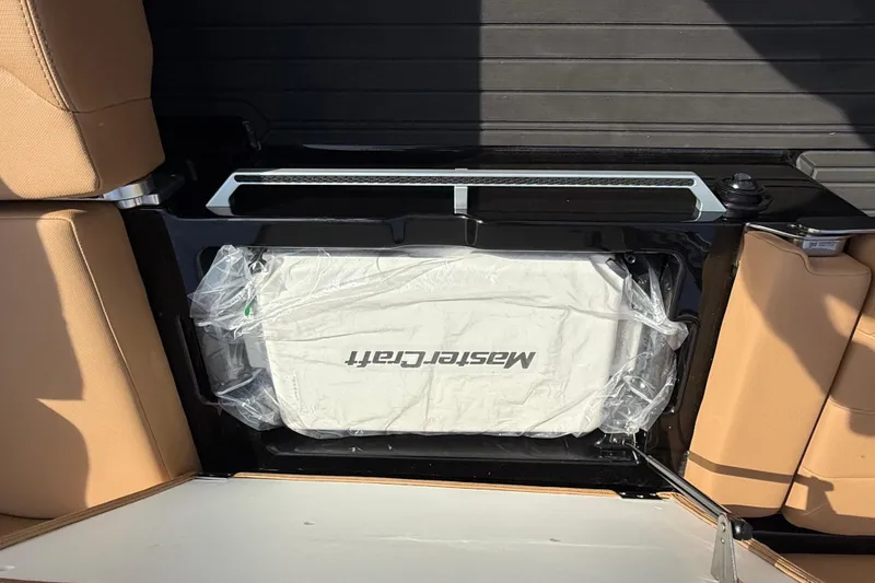 Slide: The Image of 2026 MasterCraft XT24 boat interior with tan seats and branded cooler. - 10