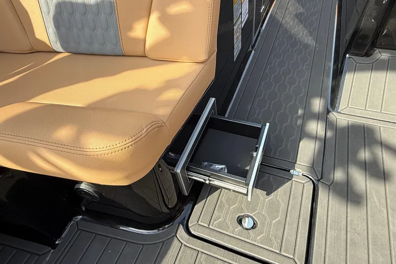 Slide: The Image of 2026 MasterCraft XT24 boat interior with tan seating and a pull-out drawer. - 9