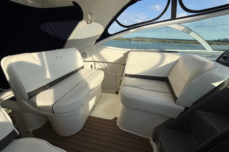 Slide: The Image of 2007 Cruisers Yachts 420 Express interior with seating and table, featuring a blue canopy. - 12