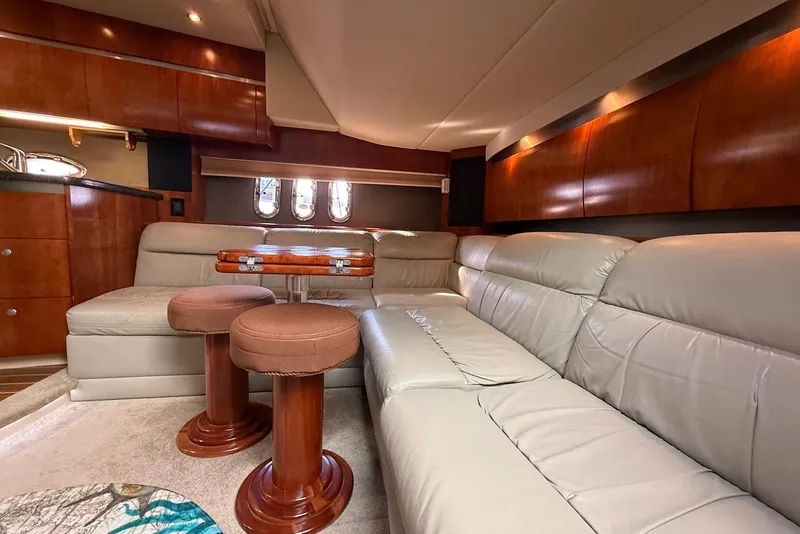 Slide: The Image of Interior view of 2007 Cruisers Yachts 420 Express with leather seating and scenic water backdrop. - 18