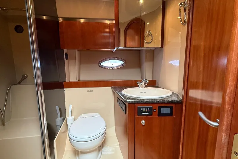 Slide: The Image of 2007 Cruisers Yachts 420 Express cabin interior with bed, TV, and wooden cabinetry. - 28