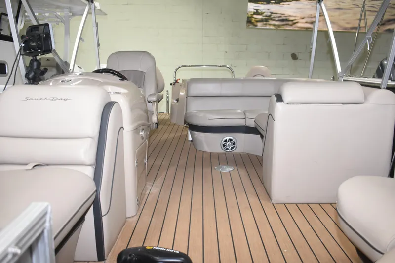 Slide: The Image of 2019 South Bay 523FCR boat interior with beige seating and wood flooring. - 12