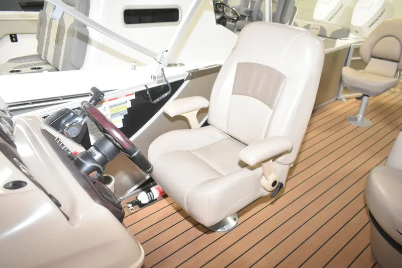 Slide: The Image of Captain's chair and helm of 2019 South Bay 523FCR boat, featuring beige upholstery. - 19