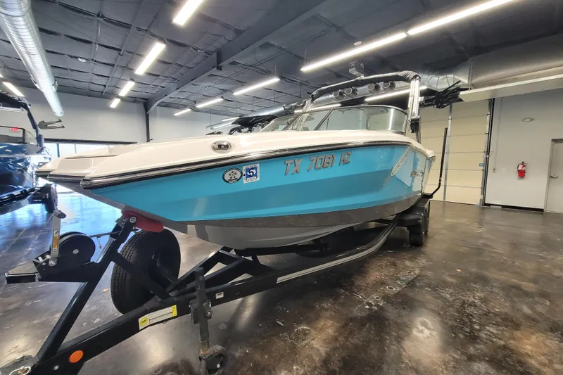 Slide: The Image of 2024 MasterCraft NXT24 boat on trailer in indoor showroom. - 11