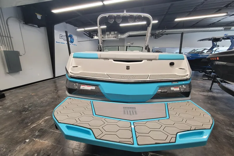 Slide: The Image of 2024 MasterCraft NXT24 boat in showroom, featuring sleek design and vibrant blue accents. - 15