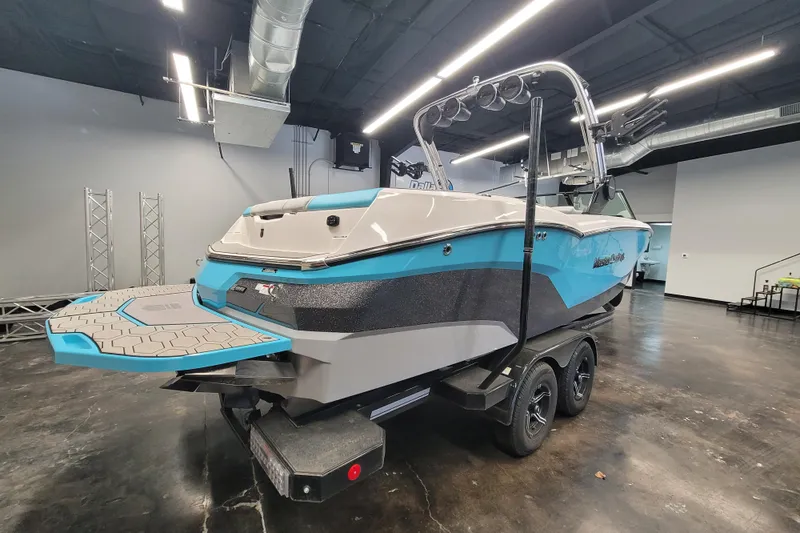Slide: The Image of 2024 MasterCraft NXT24 boat in showroom, featuring sleek design and vibrant blue accents. - 16