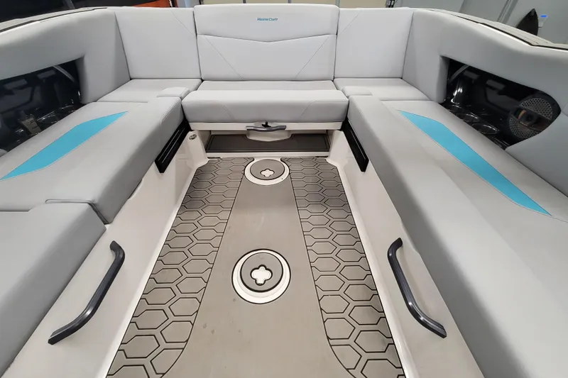 Slide: The Image of 2024 MasterCraft NXT24 boat interior with gray seating and hexagonal floor design. - 24