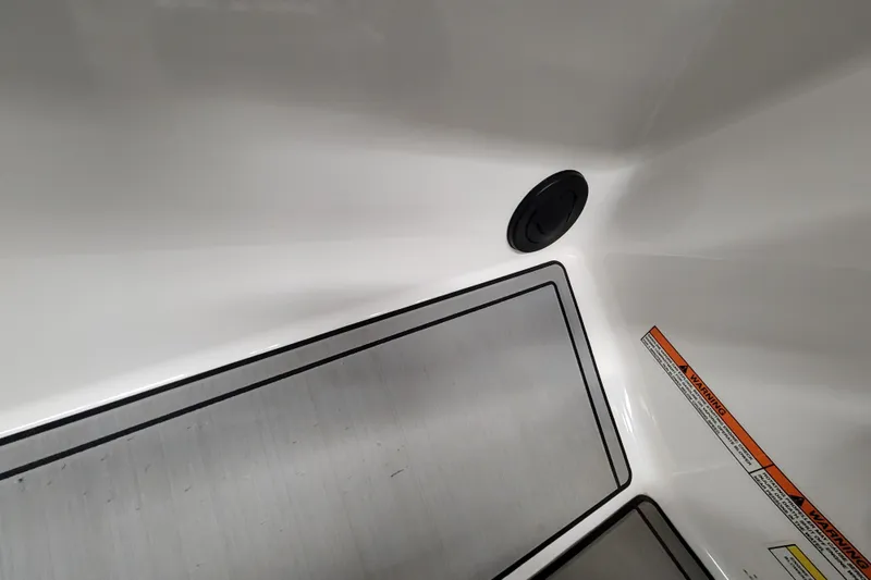 Slide: The Image of 2024 MasterCraft NXT24 boat interior with storage compartment and warning label. - 29