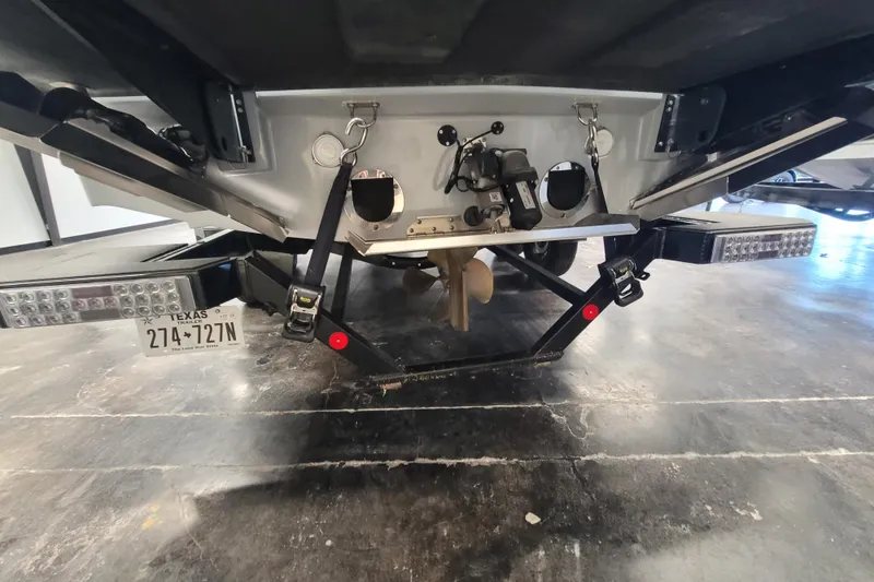 Slide: The Image of 2024 MasterCraft NXT24 boat on trailer, rear view showing propeller and license plate. - 31