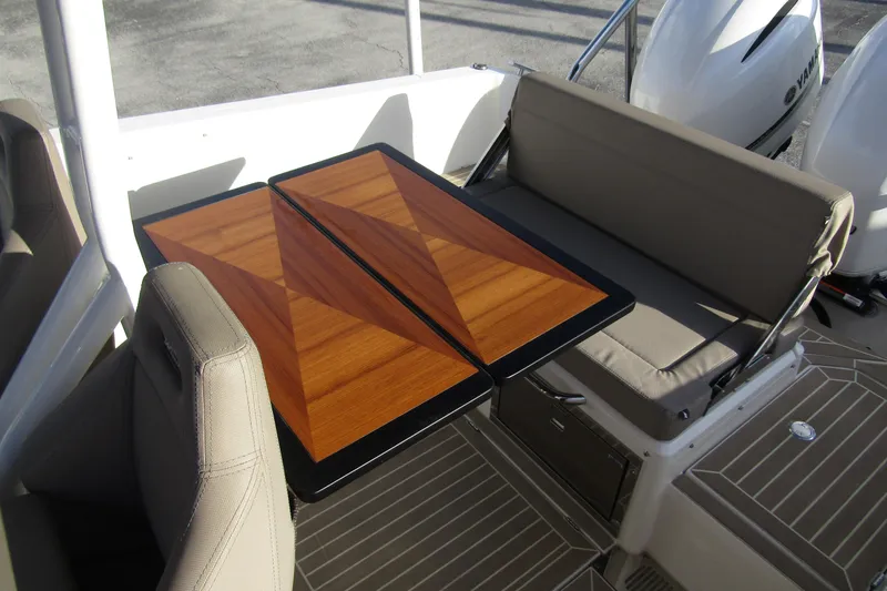 Slide: The Image of 2023 Windy SR28 CC boat interior with wooden table and cushioned seating. - 19