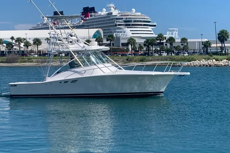 The Image of 2004 Luhrs 32 Open yacht on water with cruise ship in background. - 0