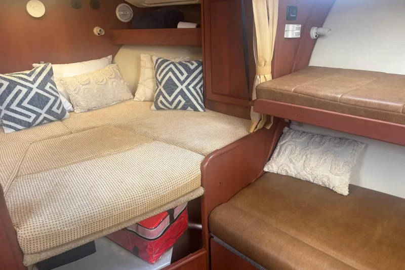 Slide: The Image of 2004 Luhrs 32 Open cabin interior with cozy bedding and decorative pillows. - 25
