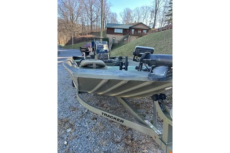 Slide: The Image of 2016 Tracker Grizzly 2072 MVX CC boat on trailer, parked outdoors near a cabin. - 13
